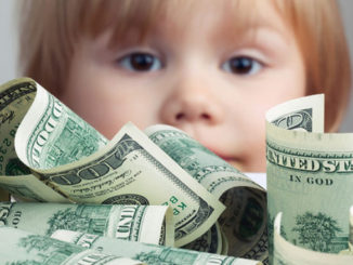 girl looking at unclaimed life insurance dollars on a table