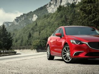 red car with insurance on the road