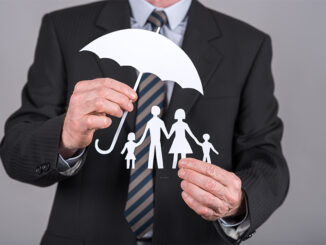 paper cut out family under umbrella