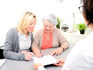 senior woman and younger woman looking over paperwork