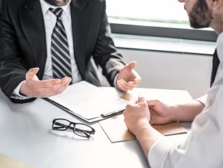 two men talking over desk group insurance article background